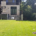 A backyard with grass and a fence.