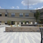 A patio area with chairs and tables in the middle of a building.