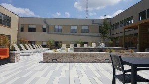 A patio area with chairs and tables in the middle of a building.