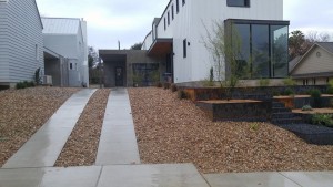 A modern home with a gravel driveway and landscaping.