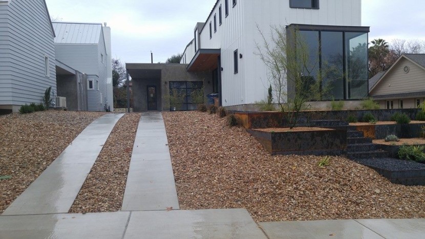 A modern home with a gravel driveway and landscaping.
